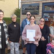 Shoppers with Kayley Morgan, and the petition, at the Copperfields village store in Blundeston following the removal of the InPost parcel locker. Picture: Mick Howes