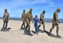Genevieve Christie, CEO of First Light Festival CIC, with the five striking 8ft (2.4m) Walking Men bronze figures on South Beach in Lowestoft. Picture: Mick Howes